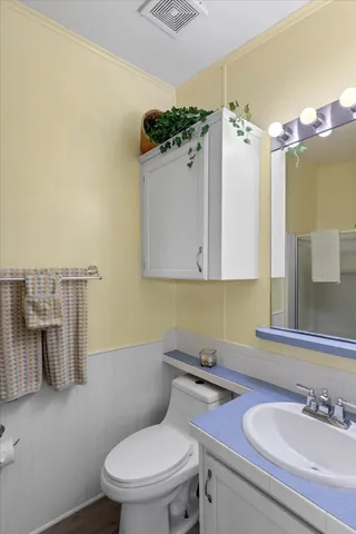 a bathroom with a sink vanity mirror and toilet