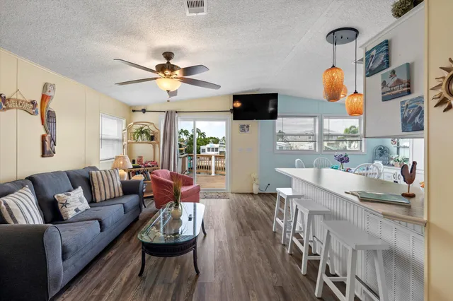 a living room with furniture kitchen view and a chandelier