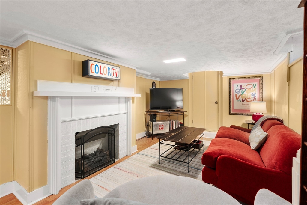 241 Weston Road Wellesley, MA 02482 - Photo 20 of 27 a living room with furniture a flat screen tv and a fireplace