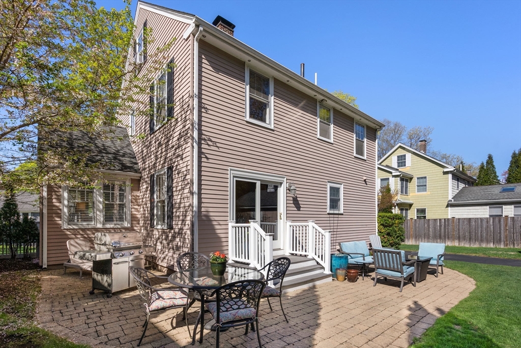 241 Weston Road Wellesley, MA 02482 - Photo 25 of 27 a backyard of a house with table and chairs