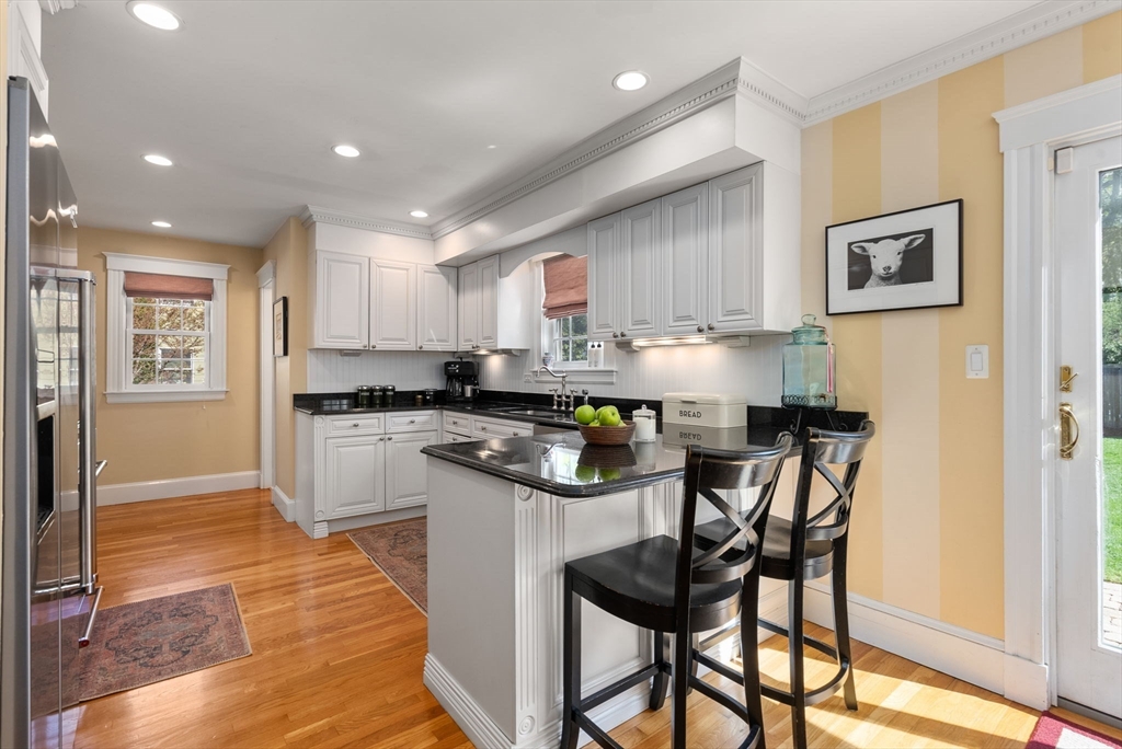 241 Weston Road Wellesley, MA 02482 - Photo 9 of 27 a kitchen with kitchen island granite countertop wooden cabinets and counter space