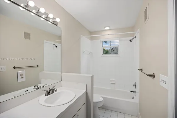 a bathroom with a sink a toilet a shower and a mirror