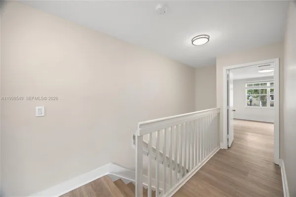 a view of a hallway with wooden floor and windows