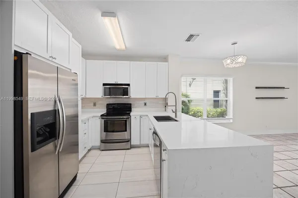 a kitchen with stainless steel appliances a refrigerator sink and microwave