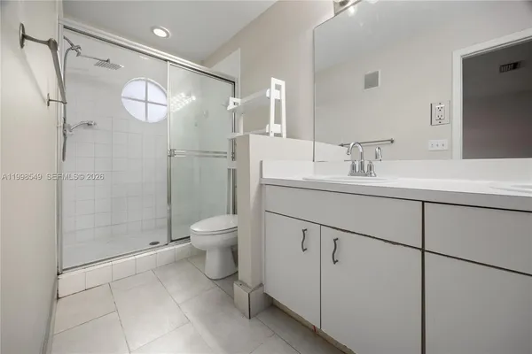 a bathroom with a shower sink vanity mirror and toilet