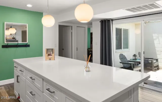 a view of a kitchen island a sink and a wooden floor