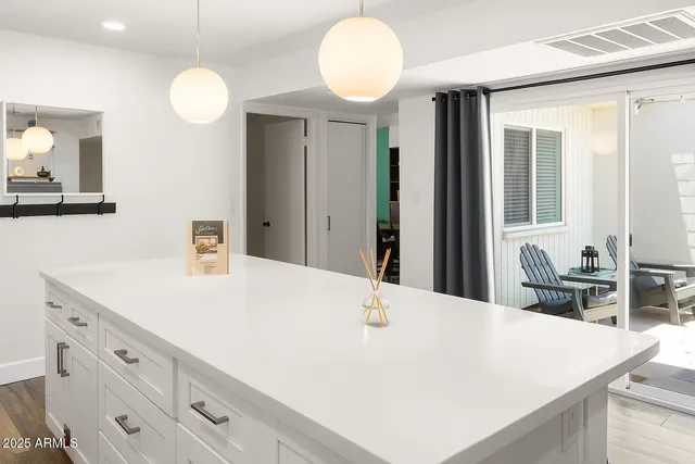 a room with kitchen island a sink and a mirror