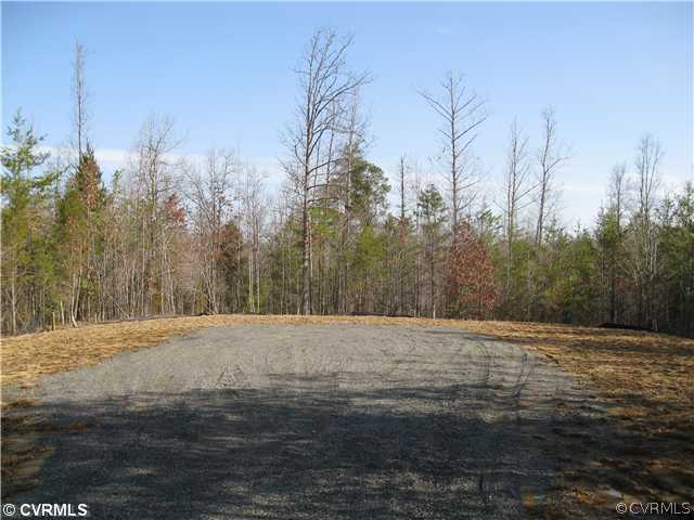 a view of dirt field with trees in the background