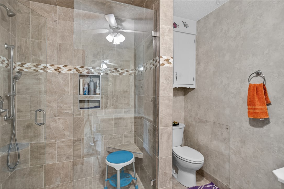 145 State Rd S-4-935 Pendleton, SC 29670 - Photo 14 of 47 Step into a well-appointed bathroom featuring a spacious tiled shower with an accent band and a practical built-in corner seat.