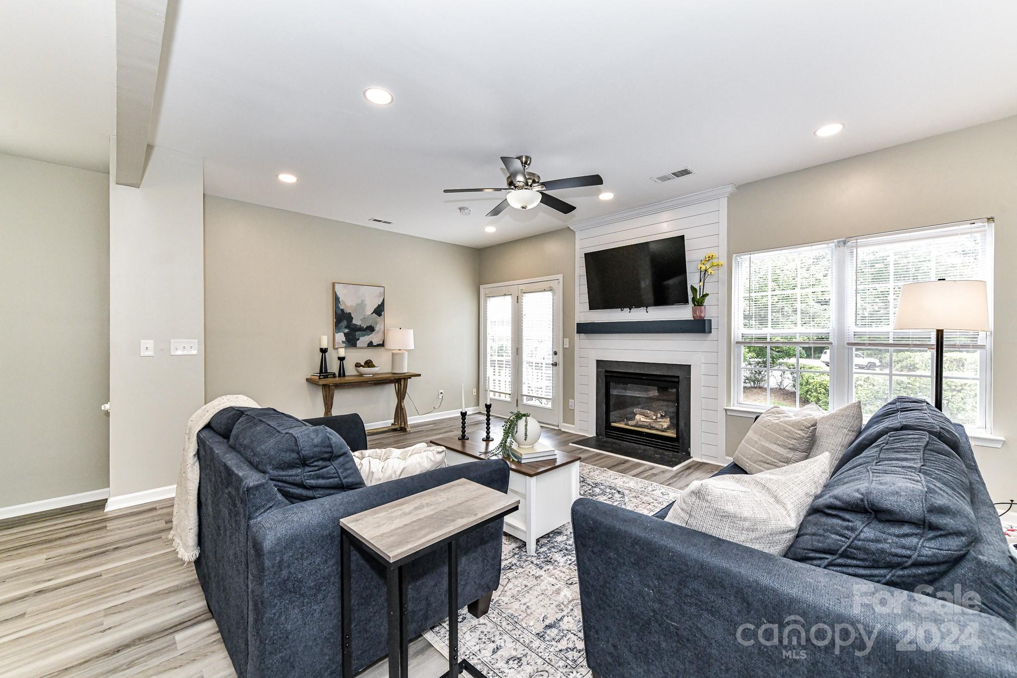 9665 Bailey Road Cornelius, NC 28031 - Photo 11 of 31 a living room with furniture a fireplace and a flat screen tv
