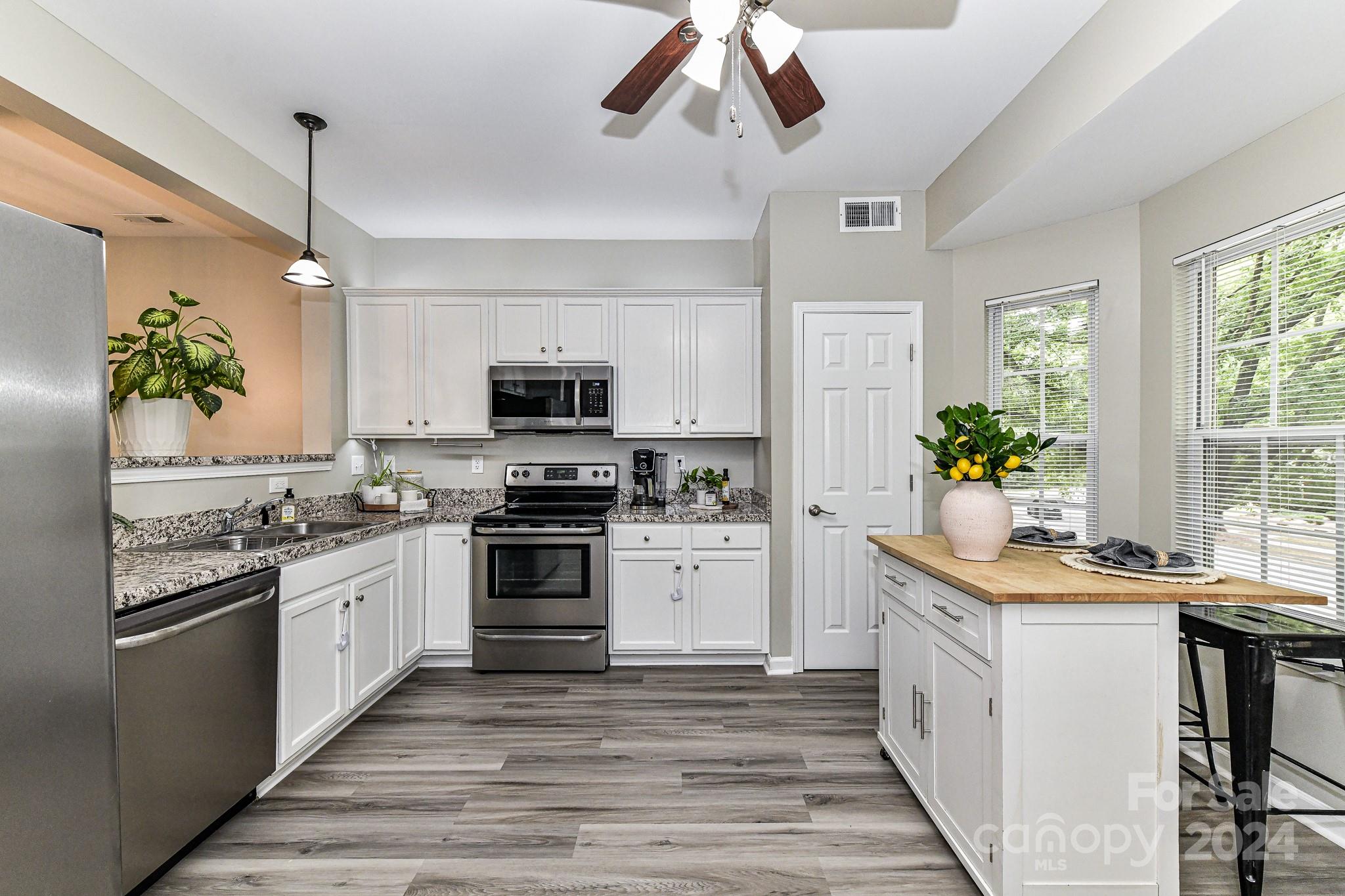 9665 Bailey Road Cornelius, NC 28031 - Photo 13 of 31 a kitchen with stainless steel appliances kitchen island granite countertop a stove a sink and a refrigerator
