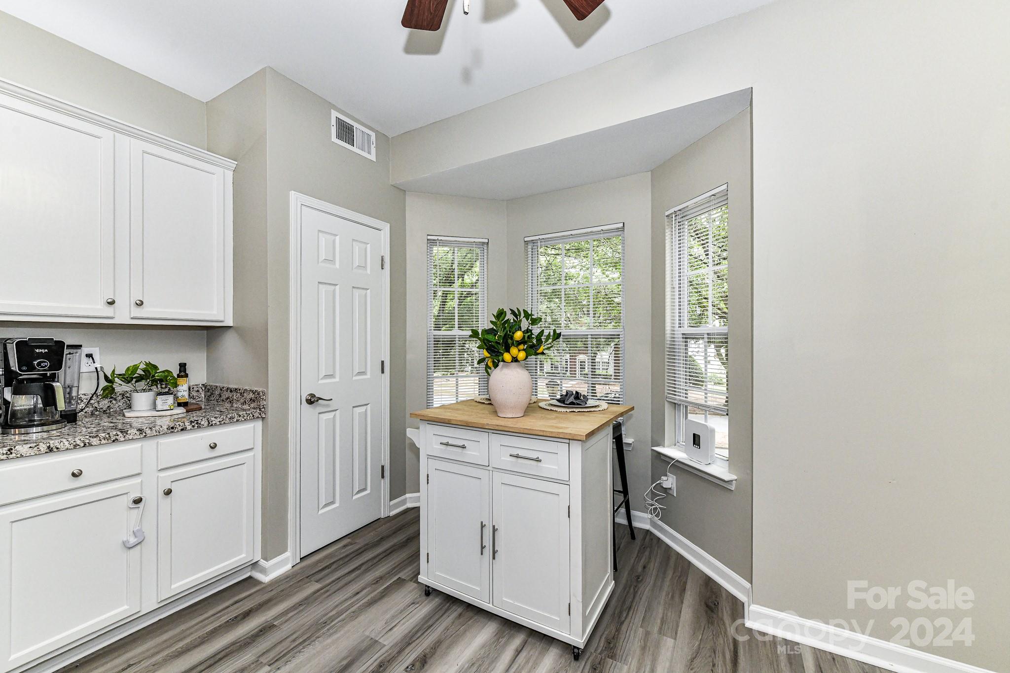 9665 Bailey Road Cornelius, NC 28031 - Photo 14 of 31 a kitchen with white cabinets and wooden floor