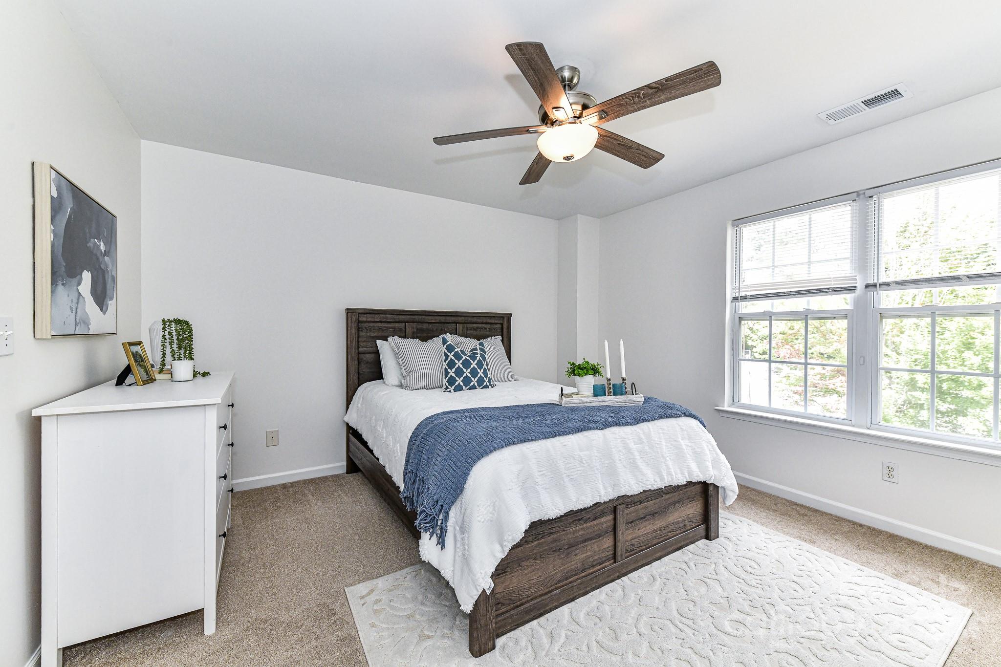 9665 Bailey Road Cornelius, NC 28031 - Photo 17 of 31 a bedroom with a large bed and a chandelier