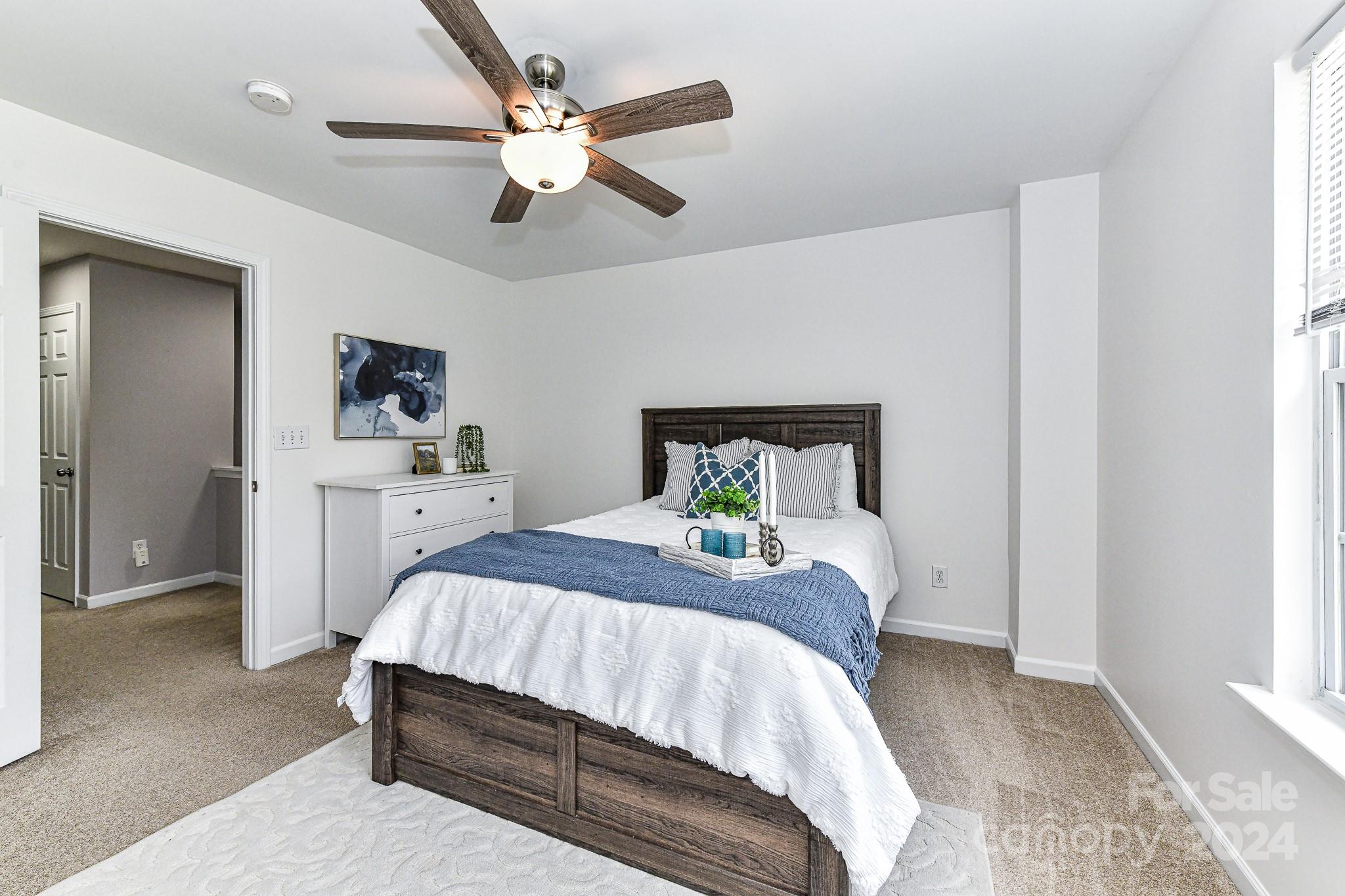 9665 Bailey Road Cornelius, NC 28031 - Photo 18 of 31 a bedroom with a bed chandelier and a window