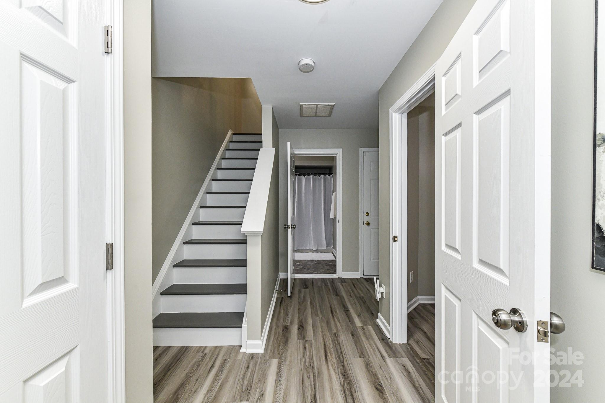 9665 Bailey Road Cornelius, NC 28031 - Photo 3 of 31 a view of a hallway with wooden floor and staircase
