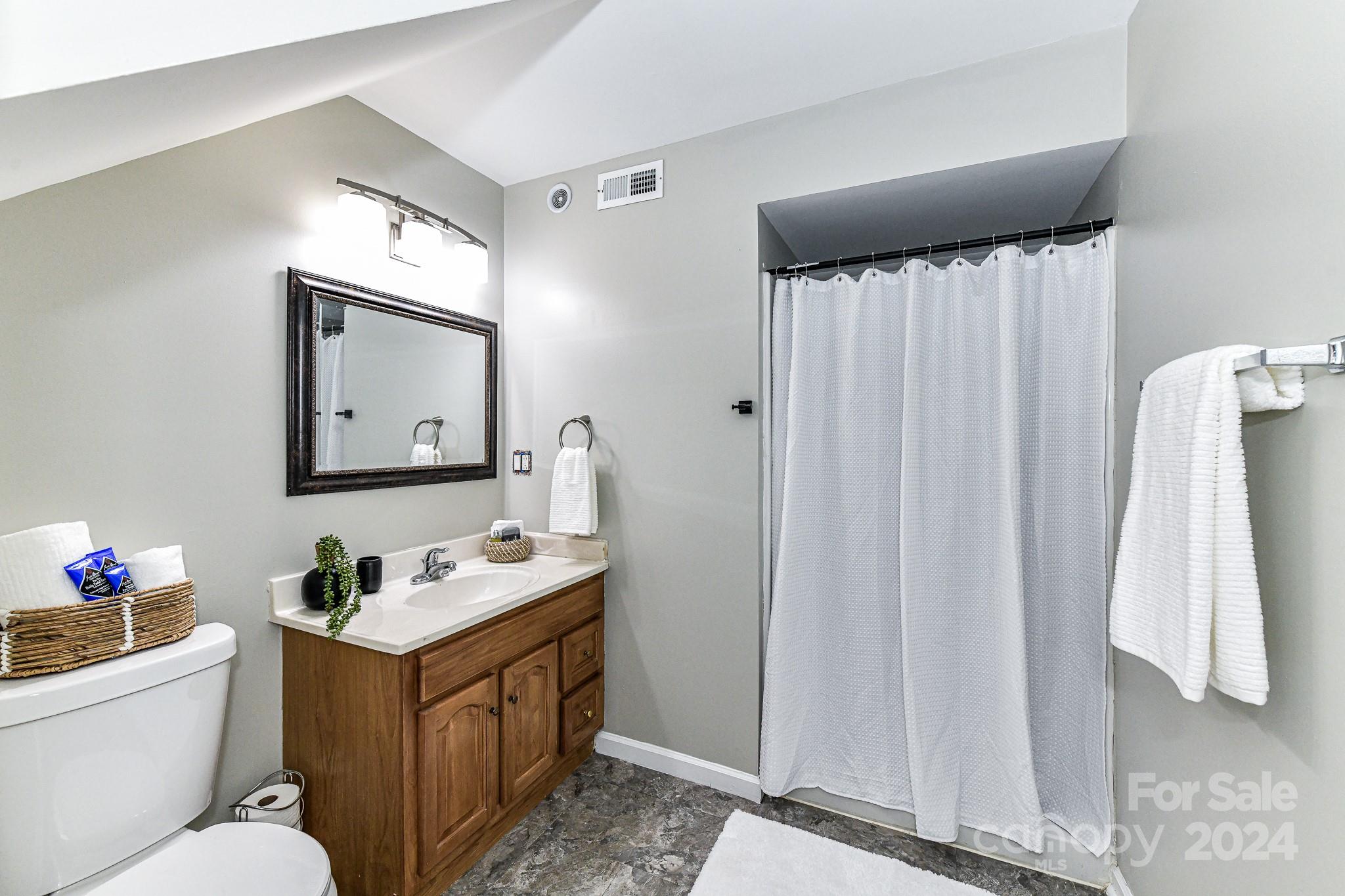 9665 Bailey Road Cornelius, NC 28031 - Photo 5 of 31 a bathroom with a toilet sink vanity tub and mirror