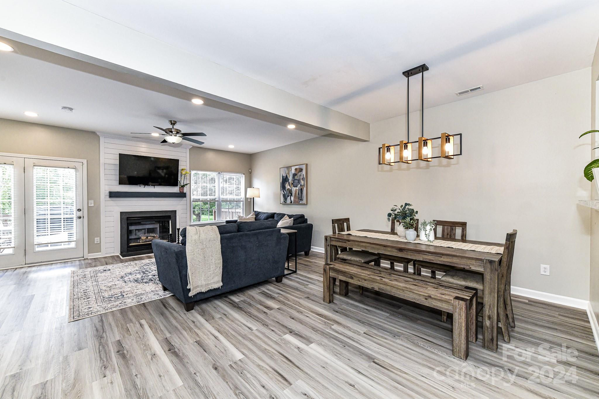 9665 Bailey Road Cornelius, NC 28031 - Photo 9 of 31 a view of a livingroom with furniture wooden floor a flat screen tv and a fireplace