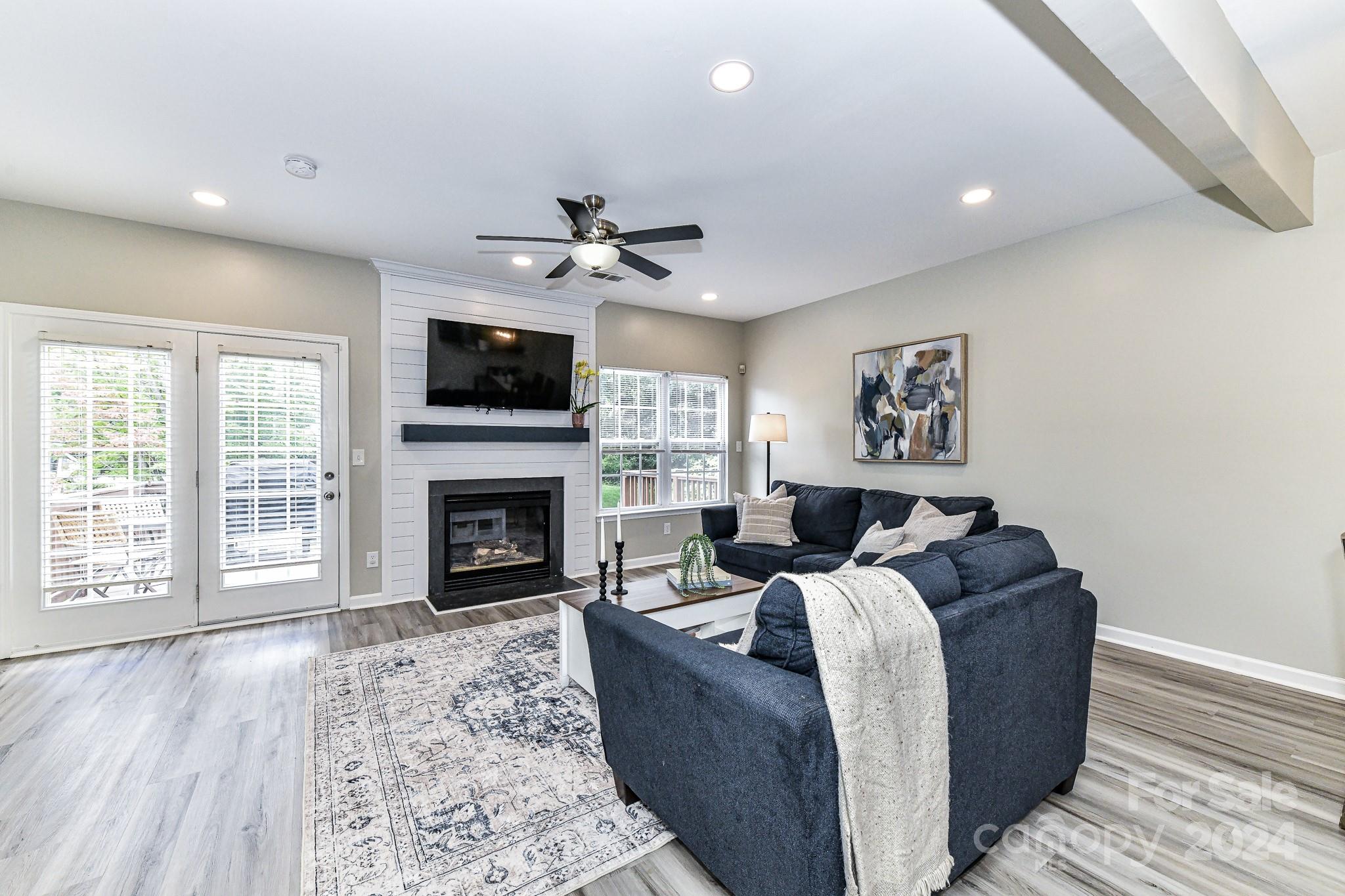 9665 Bailey Road Cornelius, NC 28031 - Photo 10 of 31 a living room with furniture a fireplace and a flat screen tv