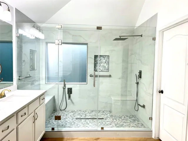a bathroom with a granite countertop sink mirror and a shower