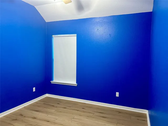 a view of a big room with wooden floor and windows