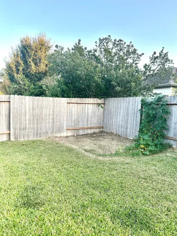 a view of a yard with a fence and trees