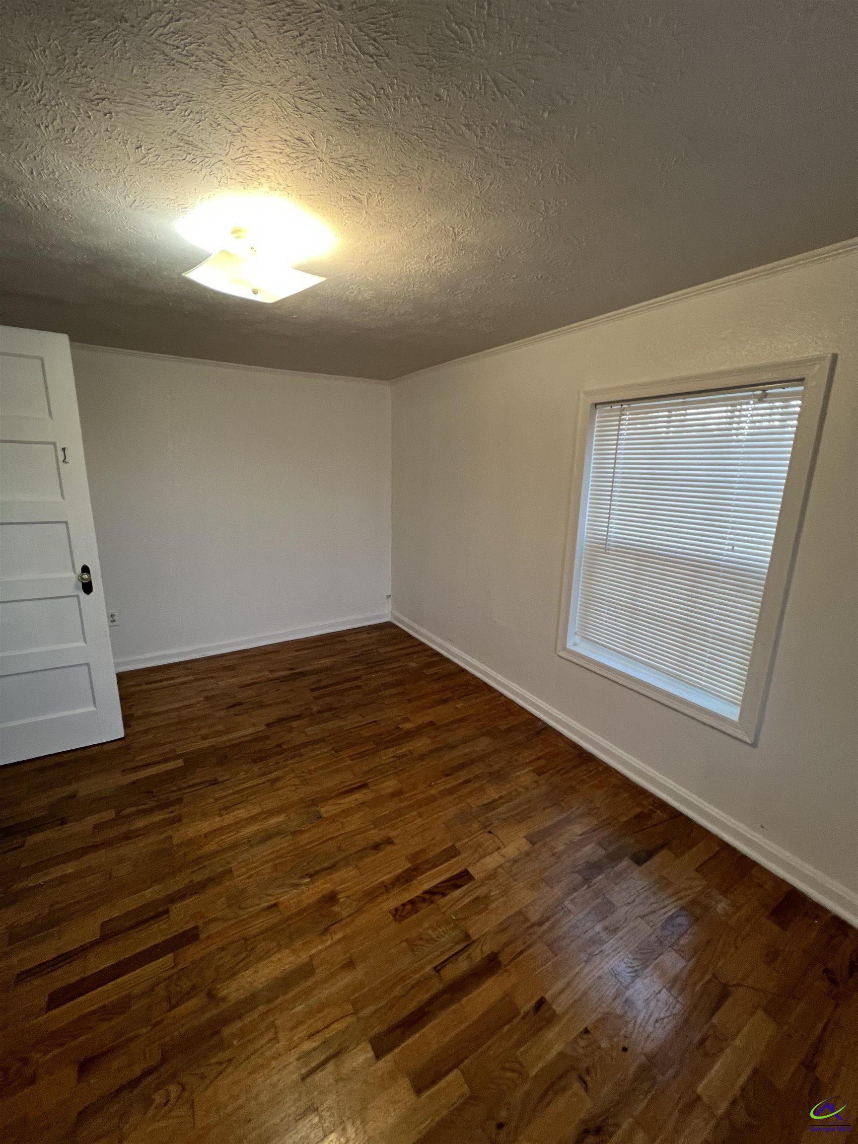 3281 State Rte 126 Dublin, GA 31021 - Photo 12 of 22 an empty room with wooden floor and windows