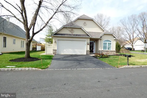 a view of road and house with trees in the background
