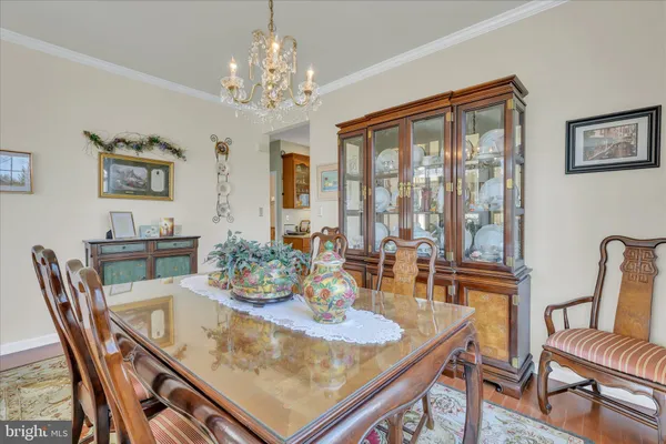 a view of a dining room with furniture a chandelier and wooden floor