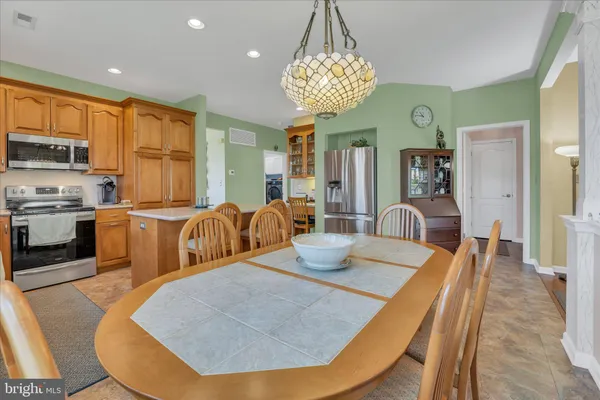 a view of a dining room with furniture a chandelier and wooden floor