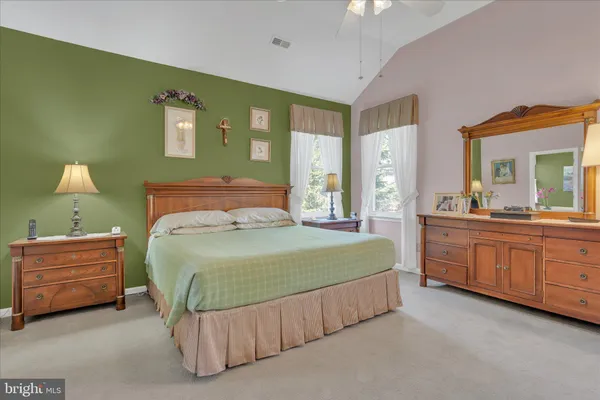 a bedroom with a bed window and dresser