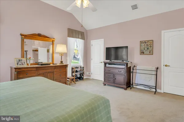 a bedroom with a bed and a flat tv screen on the dresser