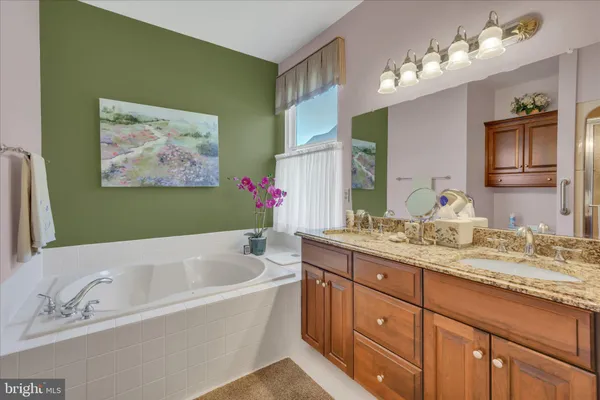 a bathroom with a tub sink and two mirror