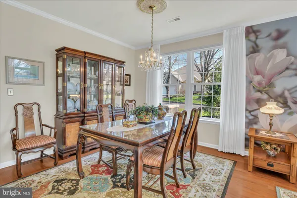 a dining room with furniture a chandelier and wooden floor