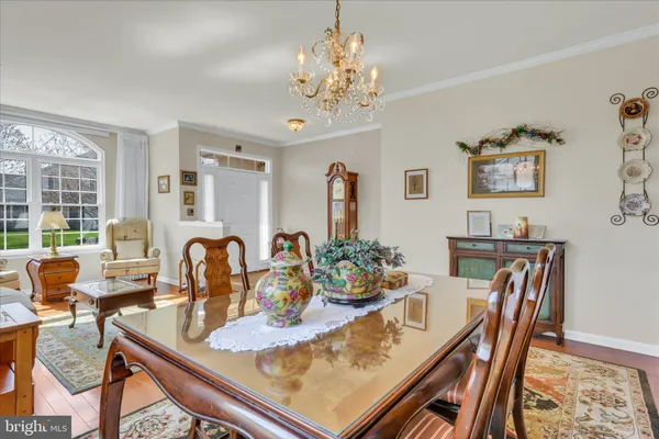 a view of a dining room with furniture a chandelier and wooden floor