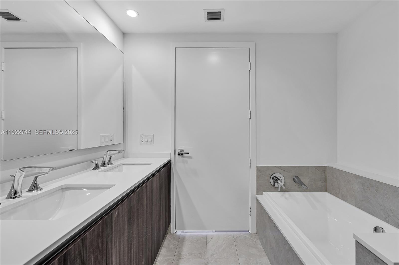 488 Northeast 18th Street, Unit 2311 Miami, FL 33132 - Photo 26 of 40 a bathroom with a tub sink and mirror