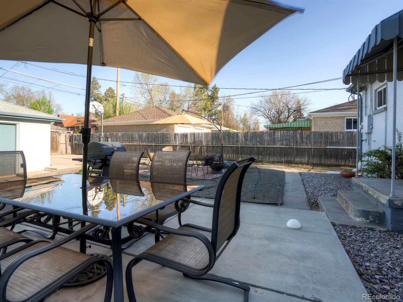 1370 Olive Street Denver, CO 80220 - Photo 21 of 27 a view of a patio with table and chairs under an umbrella