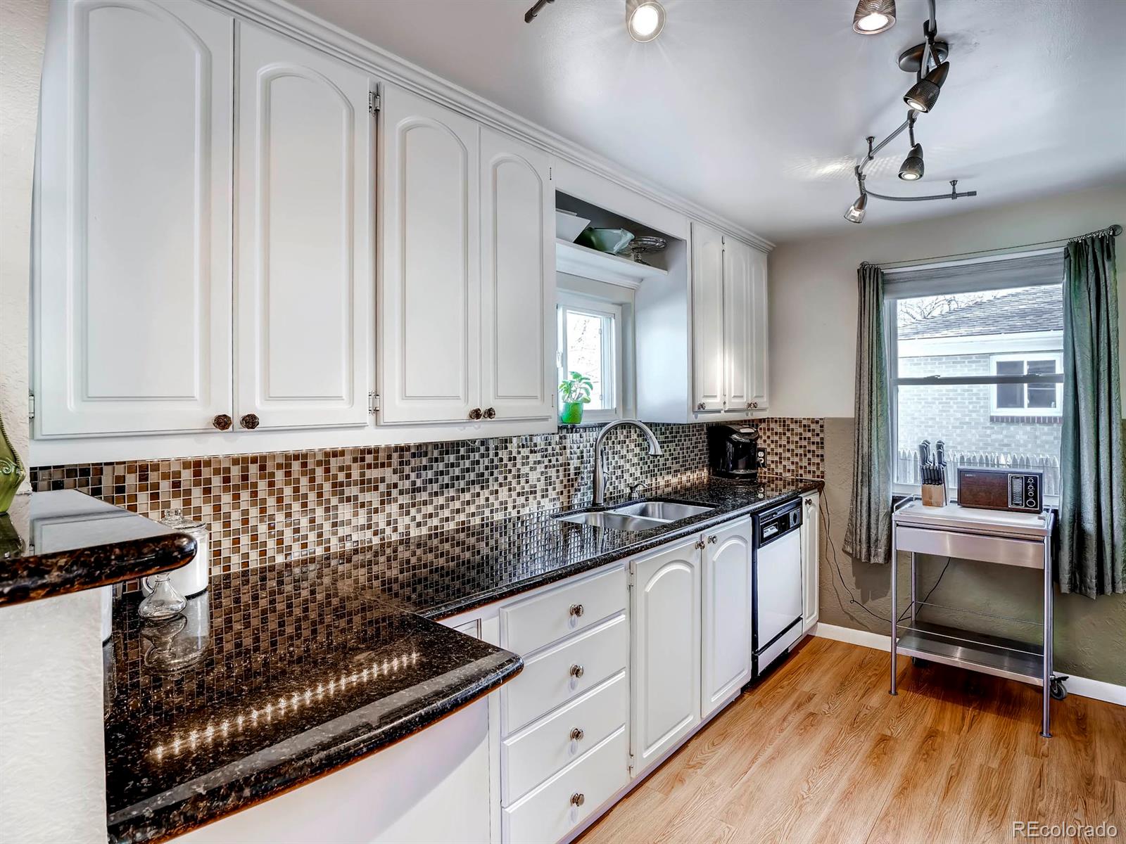 1370 Olive Street Denver, CO 80220 - Photo 7 of 27 a kitchen with granite countertop a sink and stove top oven