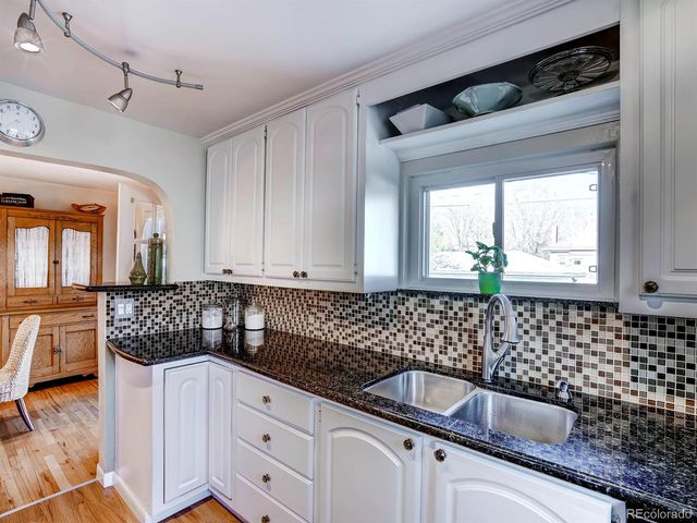 a kitchen with granite countertop a sink and cabinets