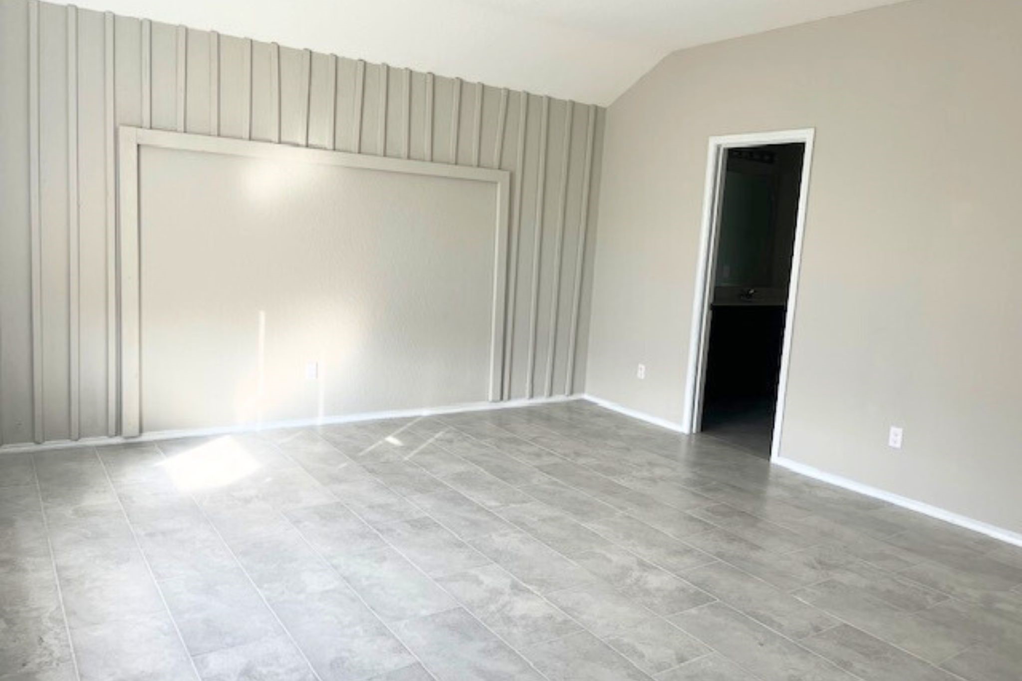 8310 Rose Petals Lane Rosharon, TX 77583 - Photo 12 of 43 pacious and comfortable primary bedroom retreat featuring elegant tile flooring, high ceilings, and a large window that fills the room with natural light. The neutral color palette creates a calm and relaxing atmosphere, while the private access to the en-suite bathroom adds convenience and comfort.