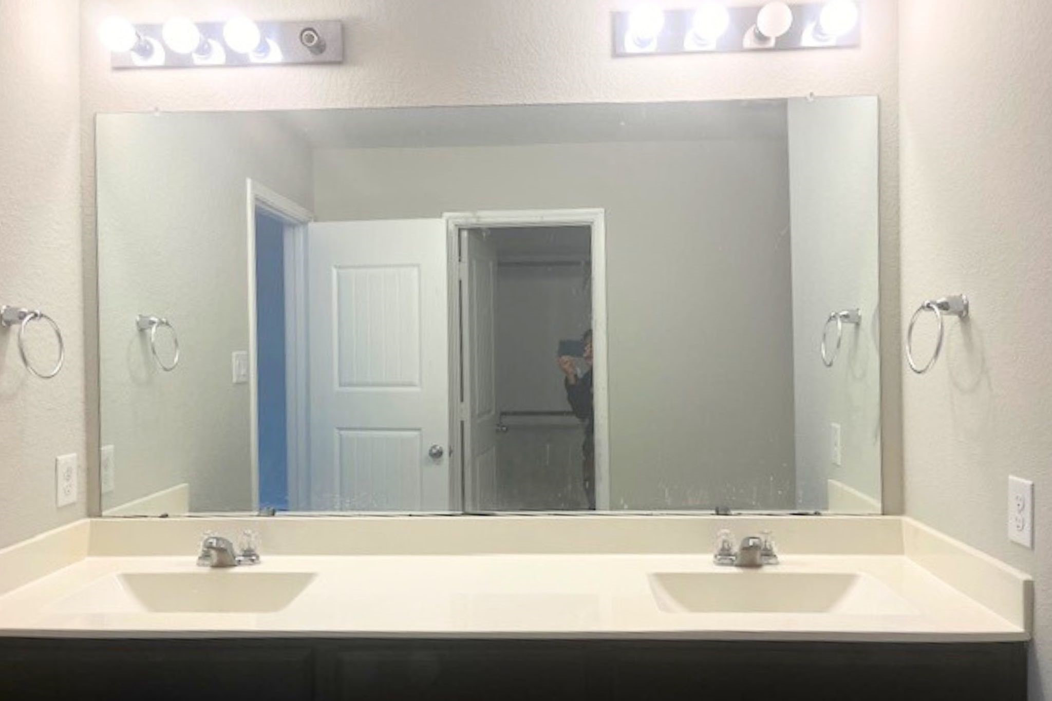 8310 Rose Petals Lane Rosharon, TX 77583 - Photo 14 of 43 Spacious primary bathroom vanity area featuring a dual-sink countertop and a large wall mirror, providing plenty of space for daily routines. Bright vanity lighting and ample counter space create a clean, functional, and comfortable area that connects conveniently to the primary bedroom and walk-in closet.