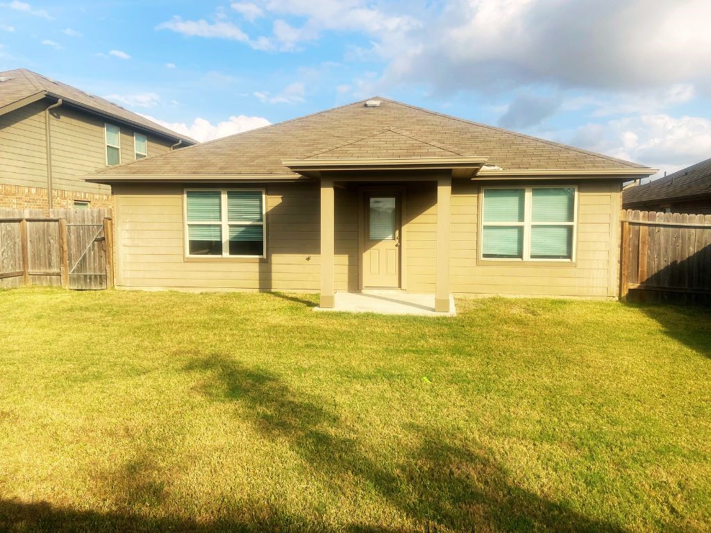 8310 Rose Petals Lane Rosharon, TX 77583 - Photo 27 of 43 View of the rear exterior of the home featuring a covered patio area, perfect for relaxing outdoors while enjoying the large fenced backyard and open space for gatherings and recreation.