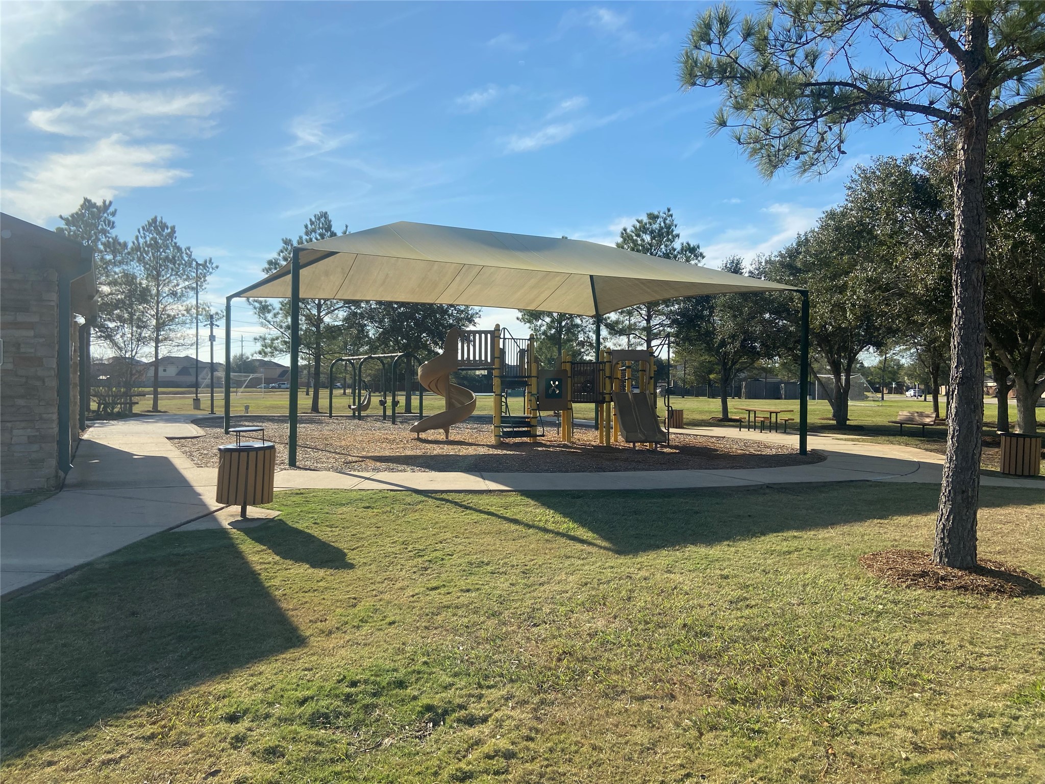8310 Rose Petals Lane Rosharon, TX 77583 - Photo 30 of 43 Shaded community playground in Southern Colony featuring a large canopy-covered play structure, slides, swings, and nearby walking paths. Surrounded by mature trees and open green space, this inviting park area offers a comfortable place for children to play and families to relax outdoors