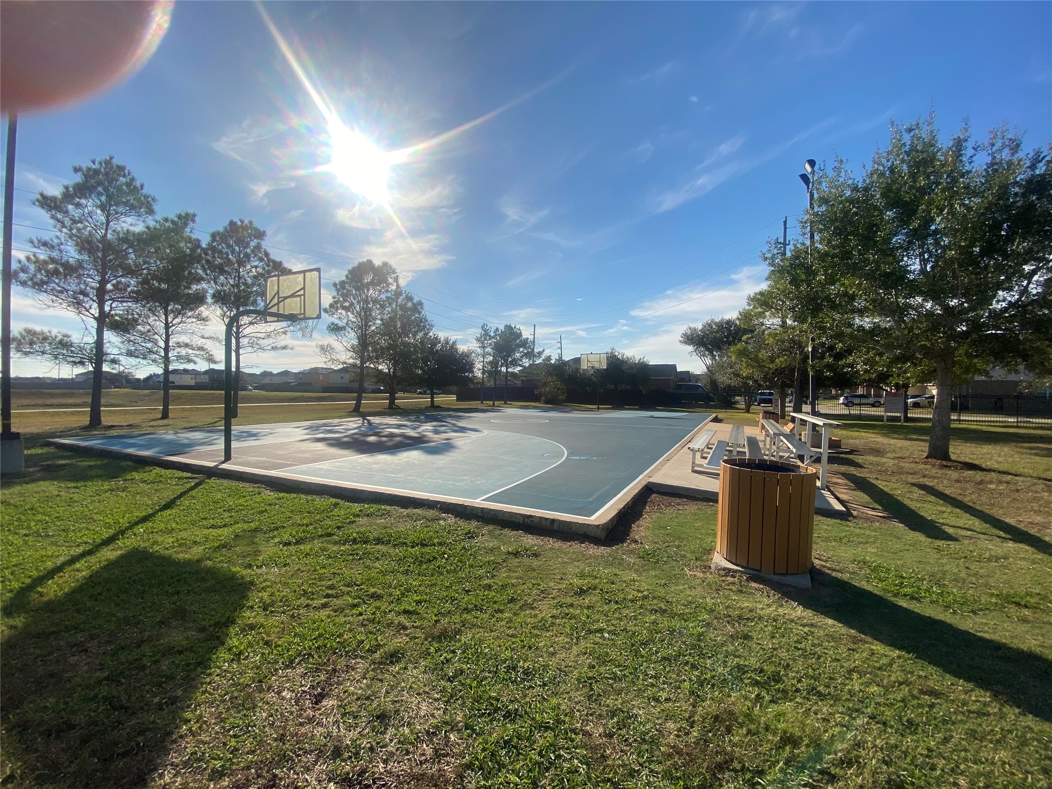 8310 Rose Petals Lane Rosharon, TX 77583 - Photo 35 of 43 Community basketball court in Southern Colony, featuring a full outdoor court with hoops and nearby seating for spectators. Surrounded by open green space and mature trees, this recreational area offers residents a great place to play, exercise, and enjoy the outdoors.