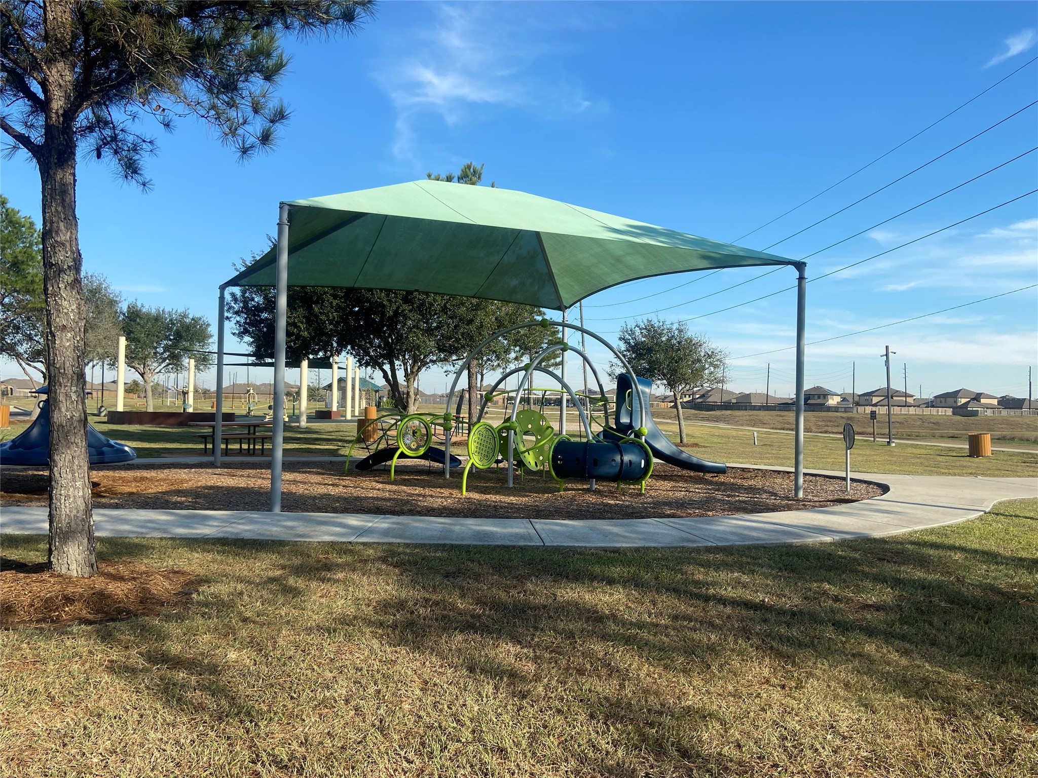 8310 Rose Petals Lane Rosharon, TX 77583 - Photo 39 of 43 Family-friendly community playground in Southern Colony featuring modern play equipment with a large shade canopy, nearby picnic tables, and surrounding walking trails. This inviting park space provides a comfortable area for children to play while families enjoy the neighborhood’s outdoor amenities.