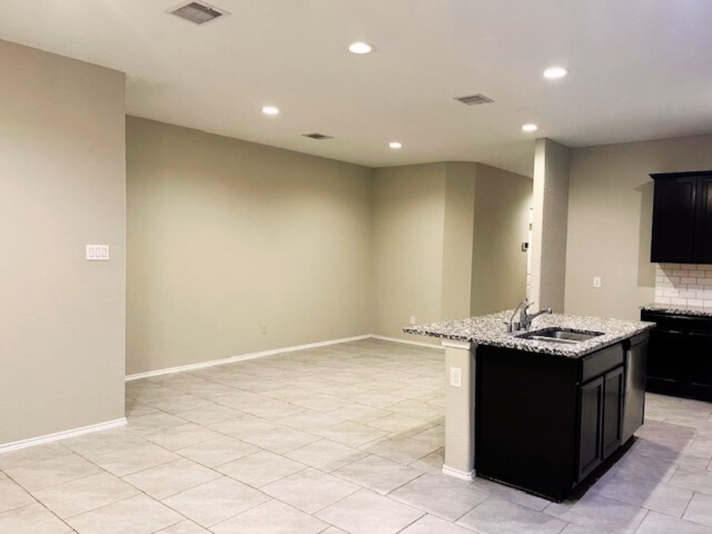 8310 Rose Petals Lane Rosharon, TX 77583 - Photo 6 of 43 Spacious open dining area conveniently located next to the kitchen, offering a bright and flexible space for everyday meals and family gatherings. The open layout, recessed lighting, and elegant tile flooring create a seamless flow between the dining, kitchen, and living areas, making this space perfect for entertaining or enjoying comfortable daily living.