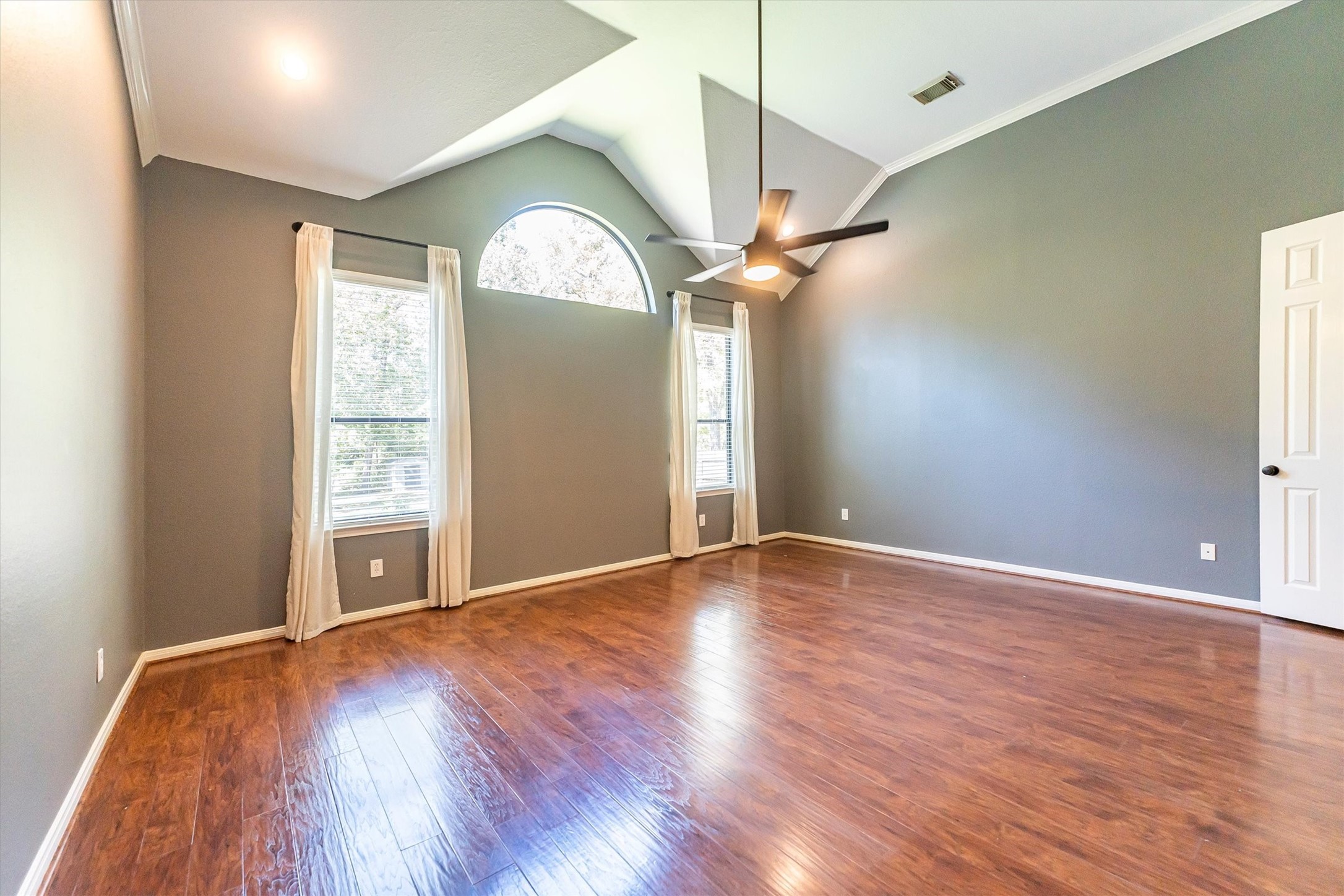 3517 Oak Landing Conroe, TX 77304 - Photo 15 of 28 an empty room with wooden floor fan and windows