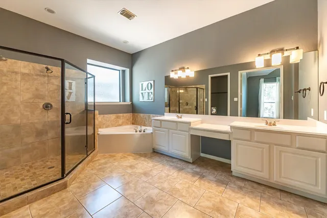 a large bathroom with a large tub shower and sink