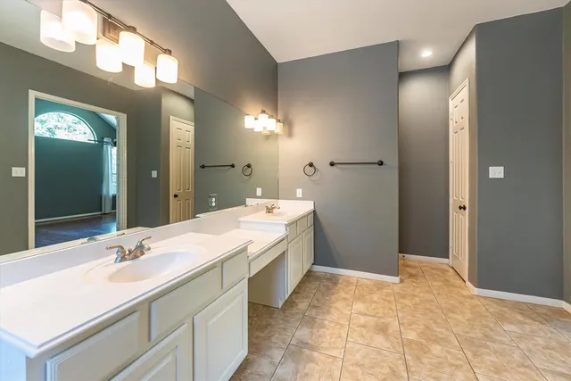 a spacious bathroom with a double vanity sink and a mirror