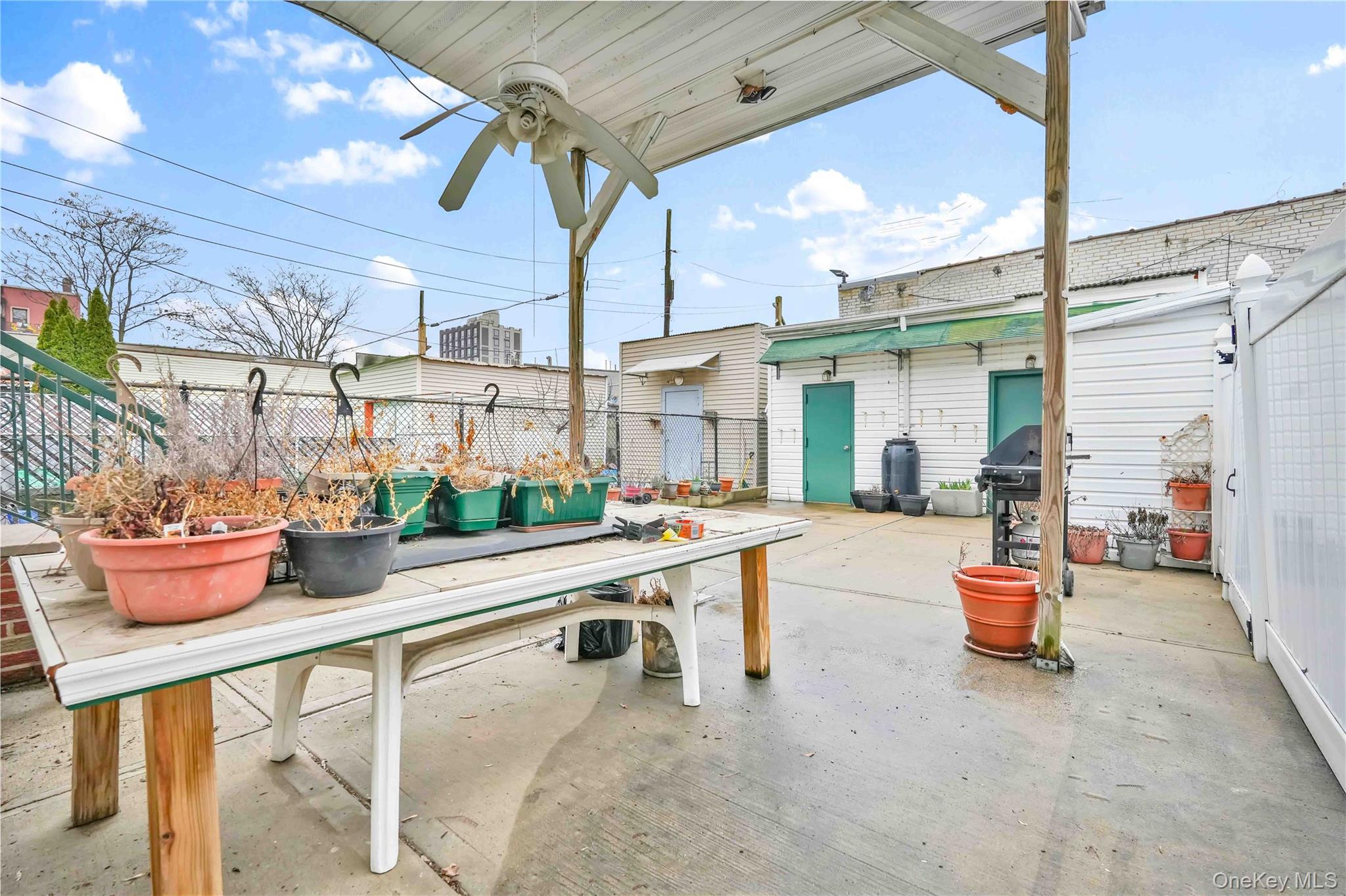 1623 George Street Queens, NY 11385 - Photo 20 of 21 a view of a patio with a dining table and chairs potted plants