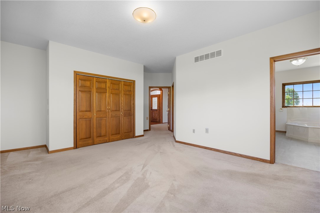 51488 Peck Wadsworth Road Wellington, OH 44090 - Photo 32 of 50 Spacious room featuring neutral carpeting, light-toned walls, and a ceiling-mounted light fixture